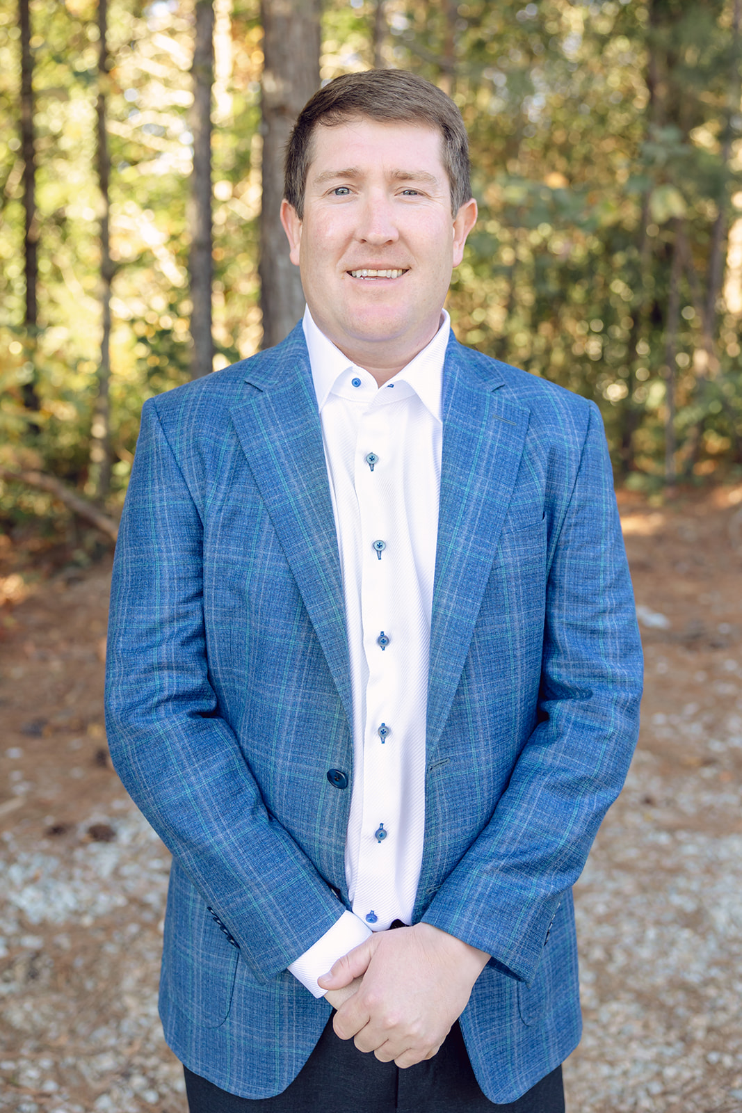 A man in a blue suit standing outside.