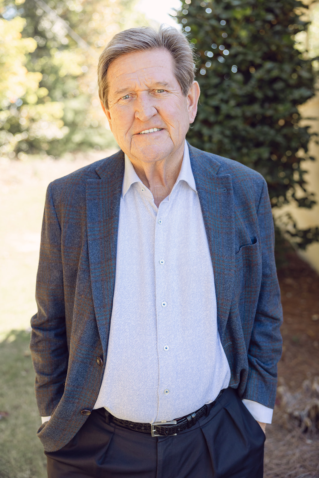 A man in a suit and tie standing outside.