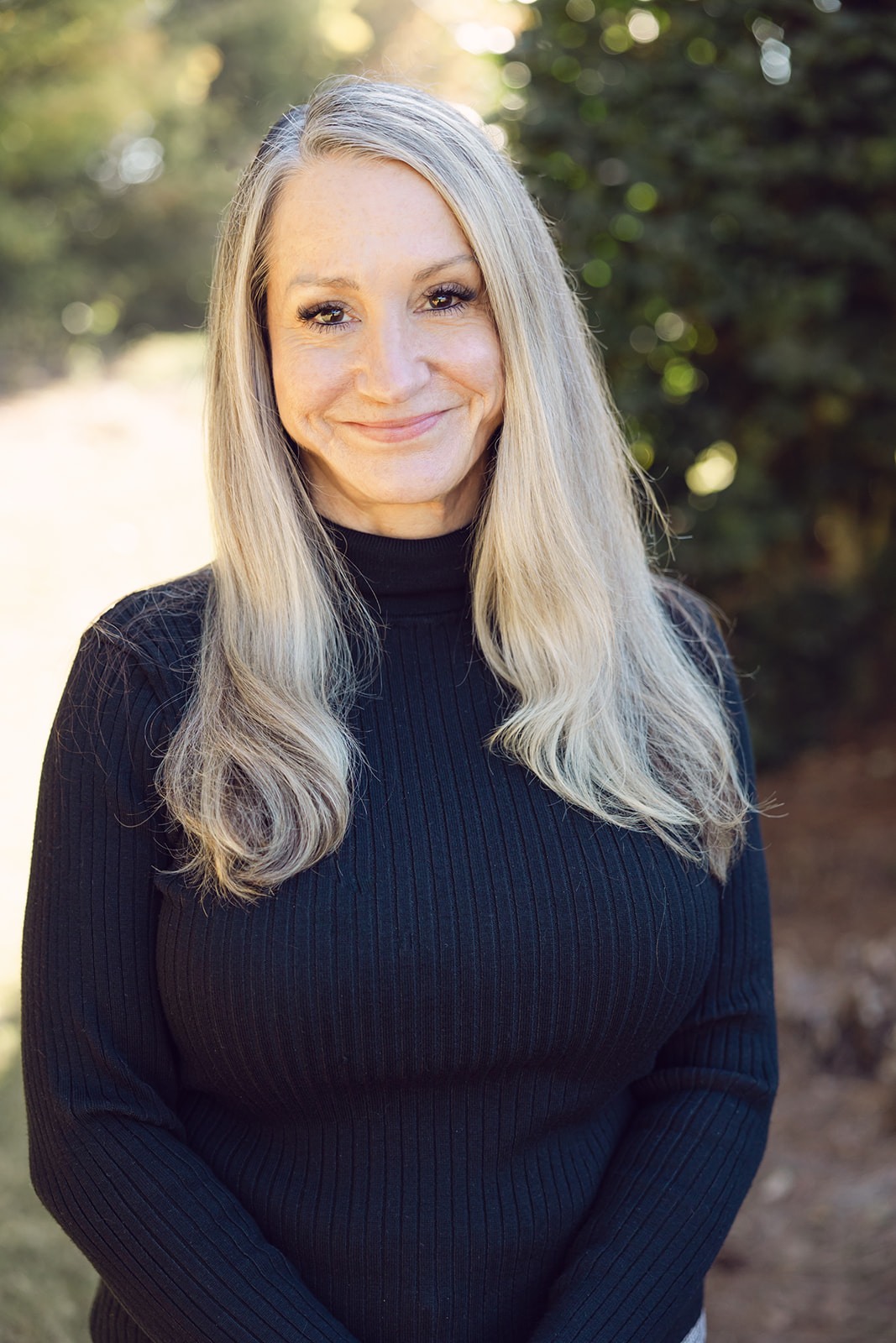 A woman with long blonde hair wearing a black sweater.