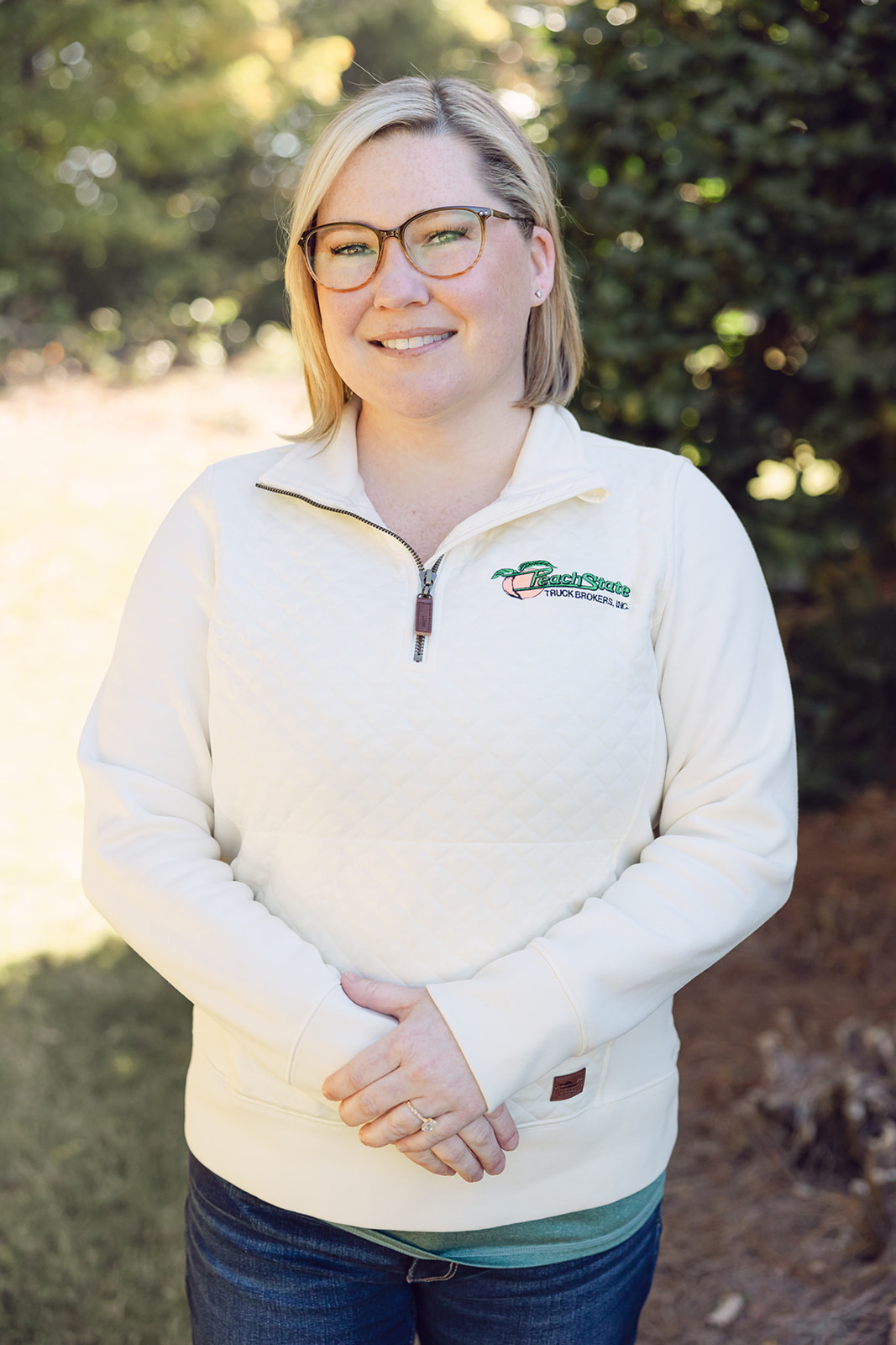 A woman wearing glasses and a white sweater.