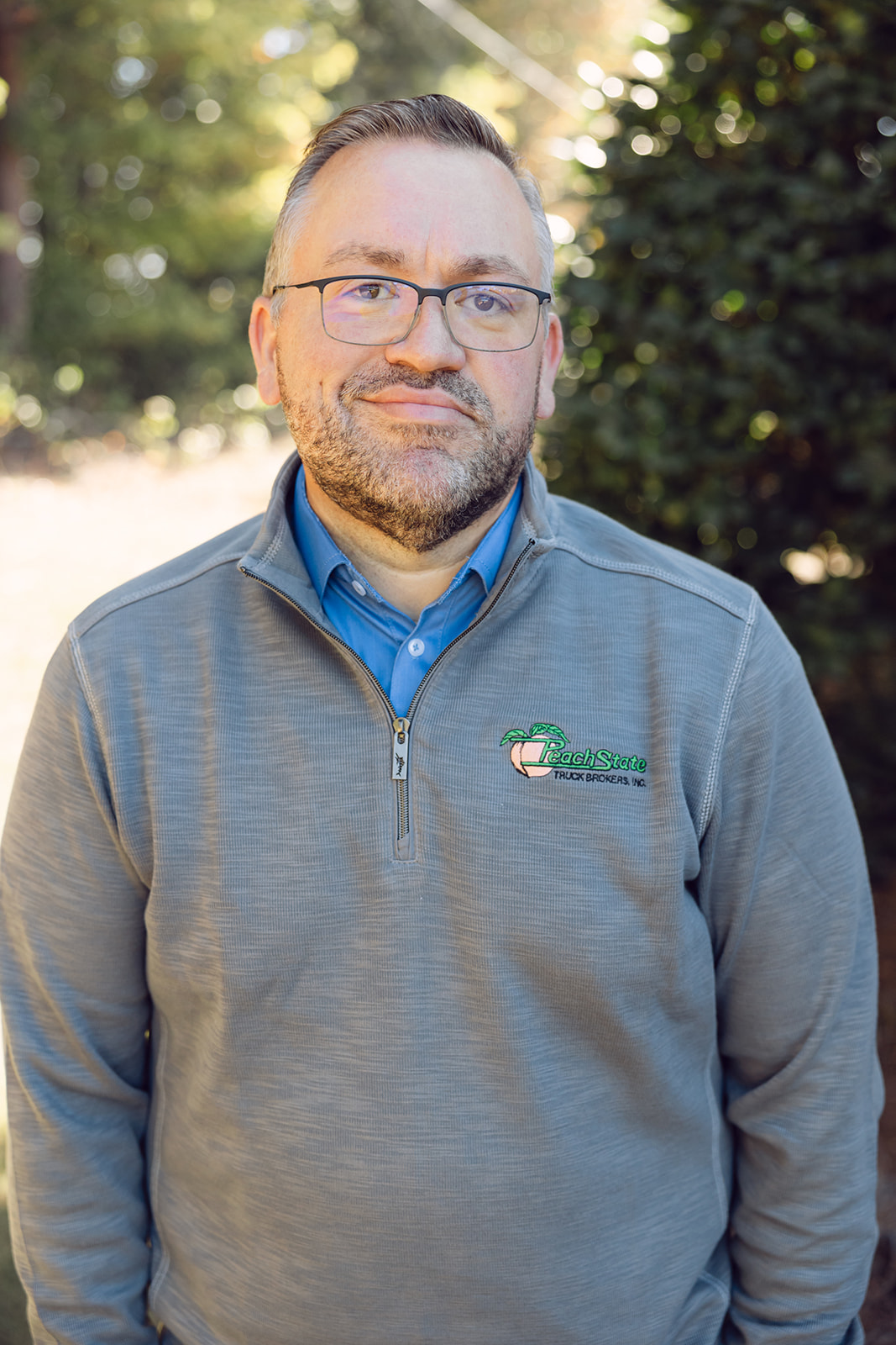 A man in glasses and a gray sweater