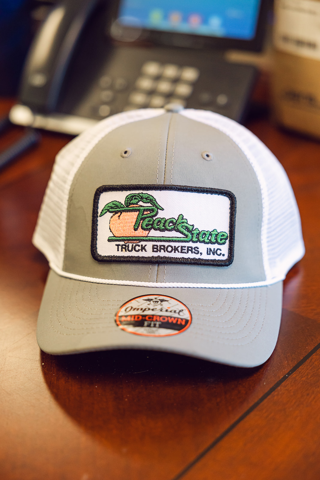 A gray and white trucker hat with the words " peach state truck brokers, inc." on it.
