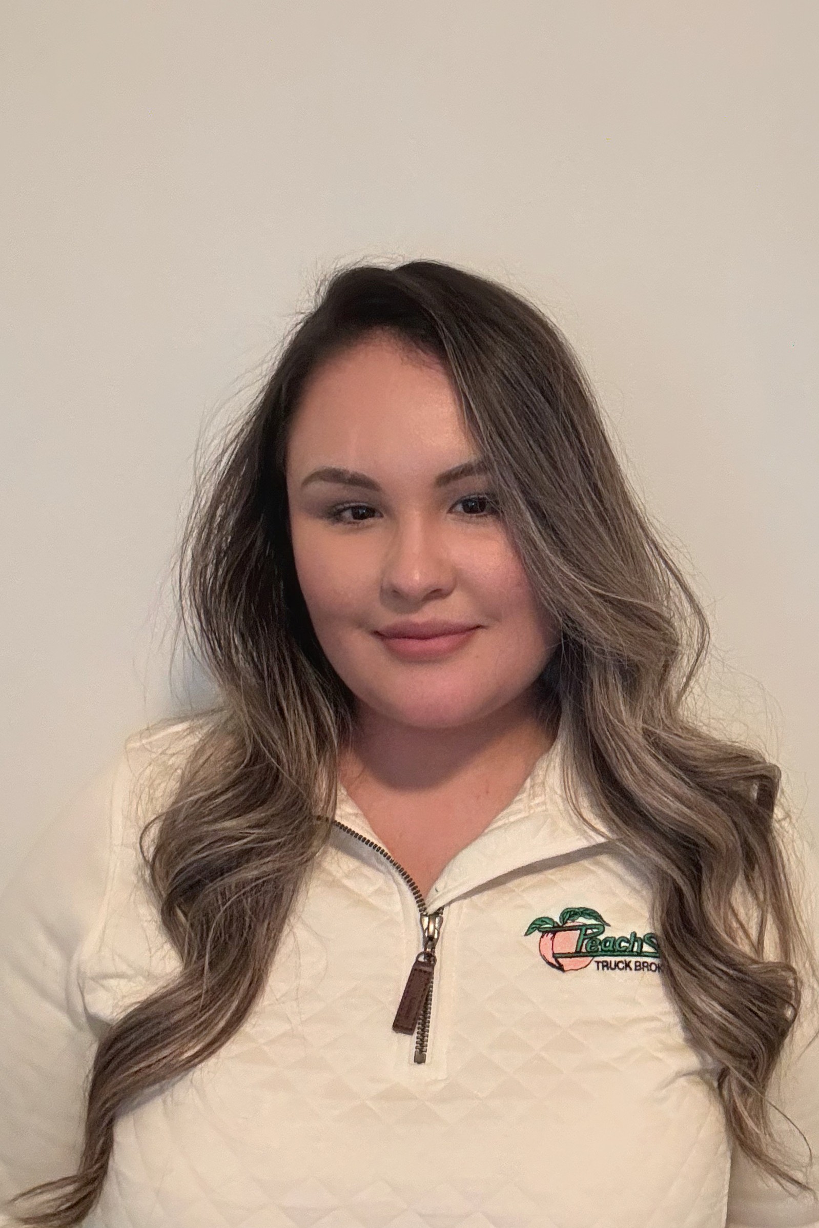 A woman with long hair wearing a white jacket.