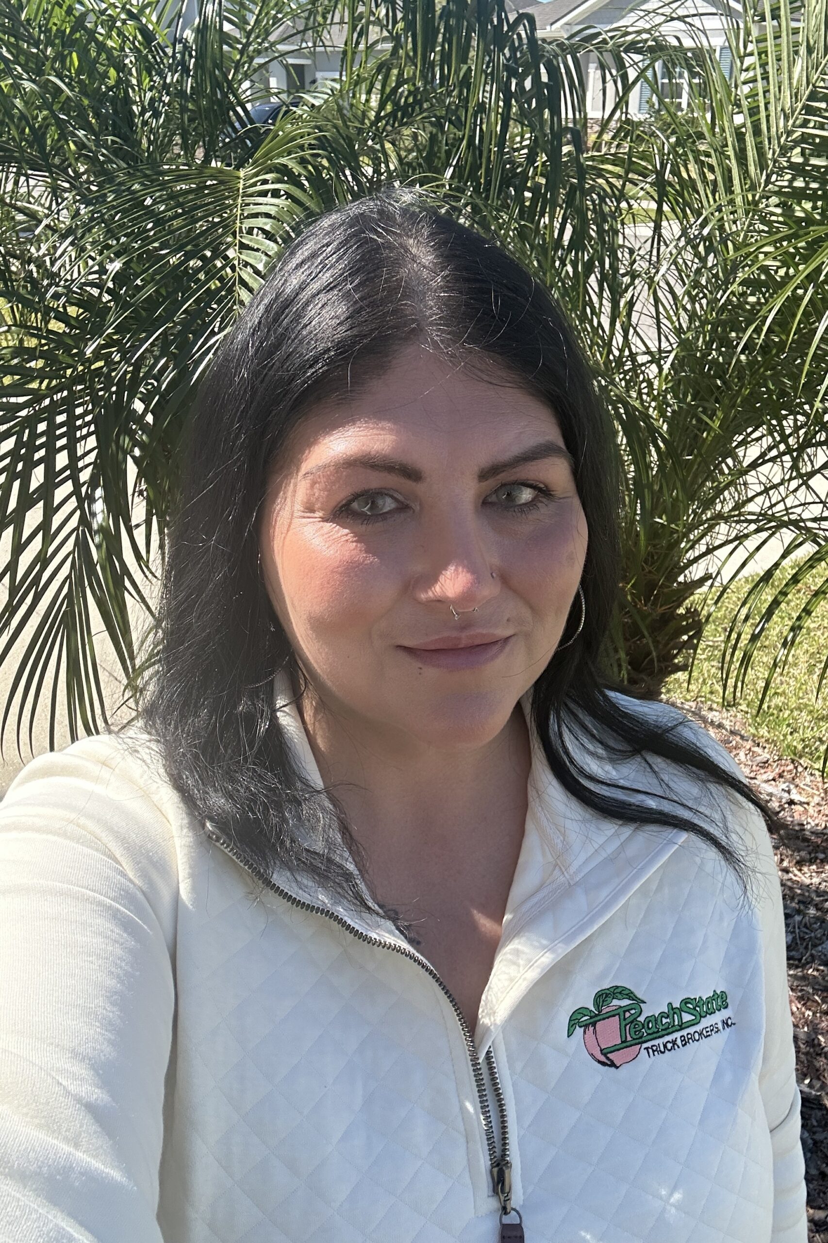A woman with long black hair wearing white shirt.