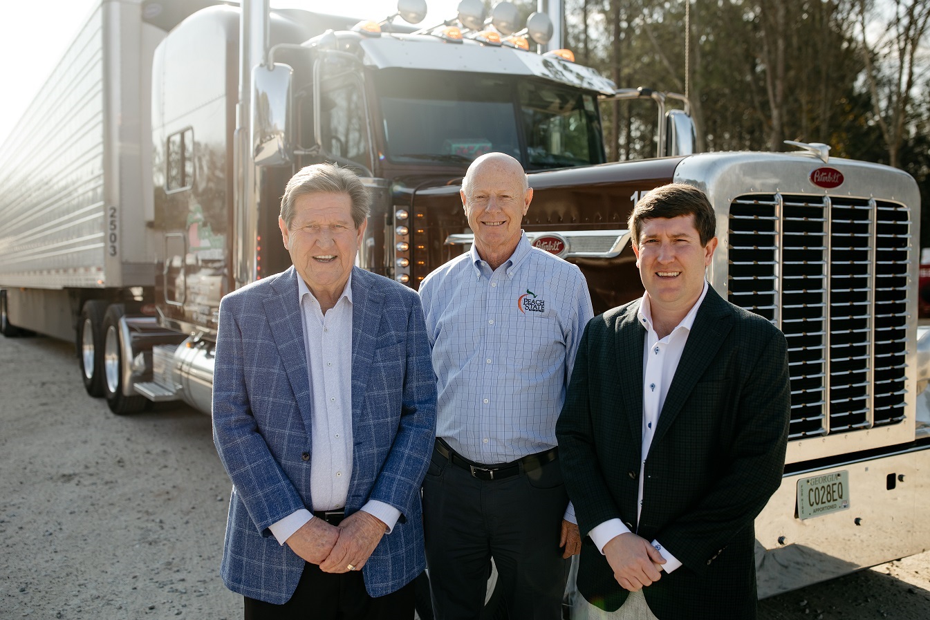Three men standing in front of a large truck.